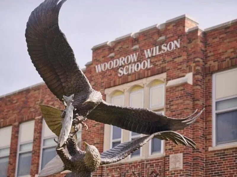 Exterior of a brick building, with a paved walkway leading to a door