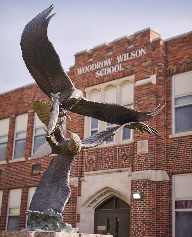 Exterior of a brick building, with a paved walkway leading to a door