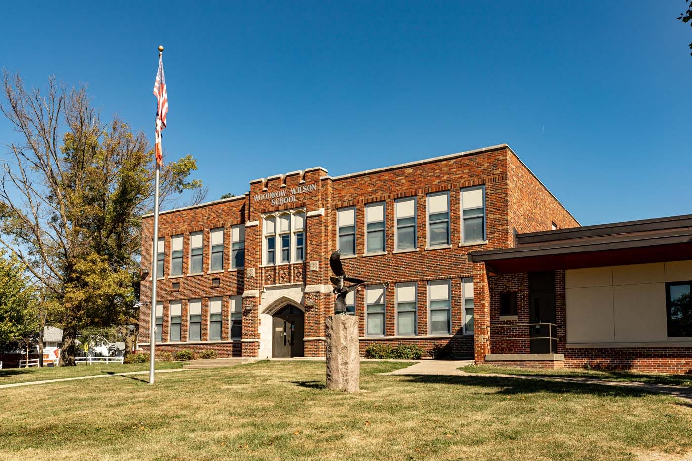 Exterior of a brick building, with a paved walkway leading to a door