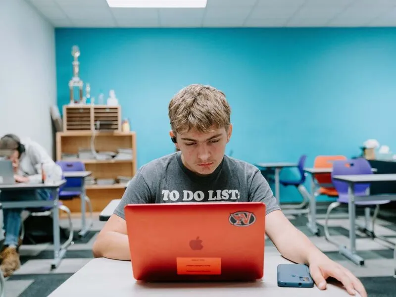 Students in their classroom, using a laptop to complete school assignments.