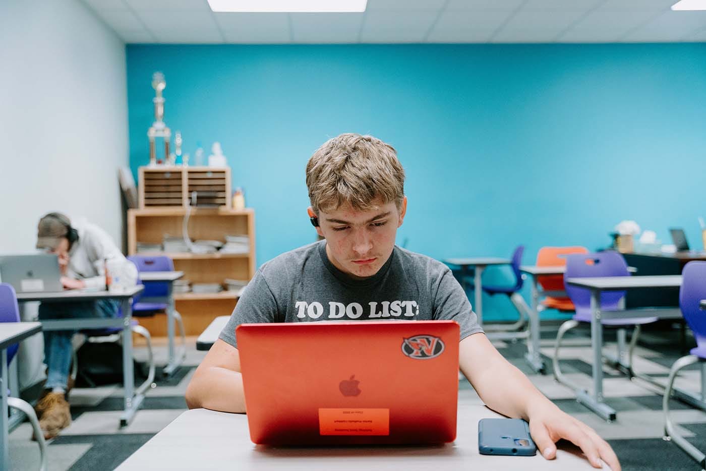 Students in their classroom, using a laptop to complete school assignments.
