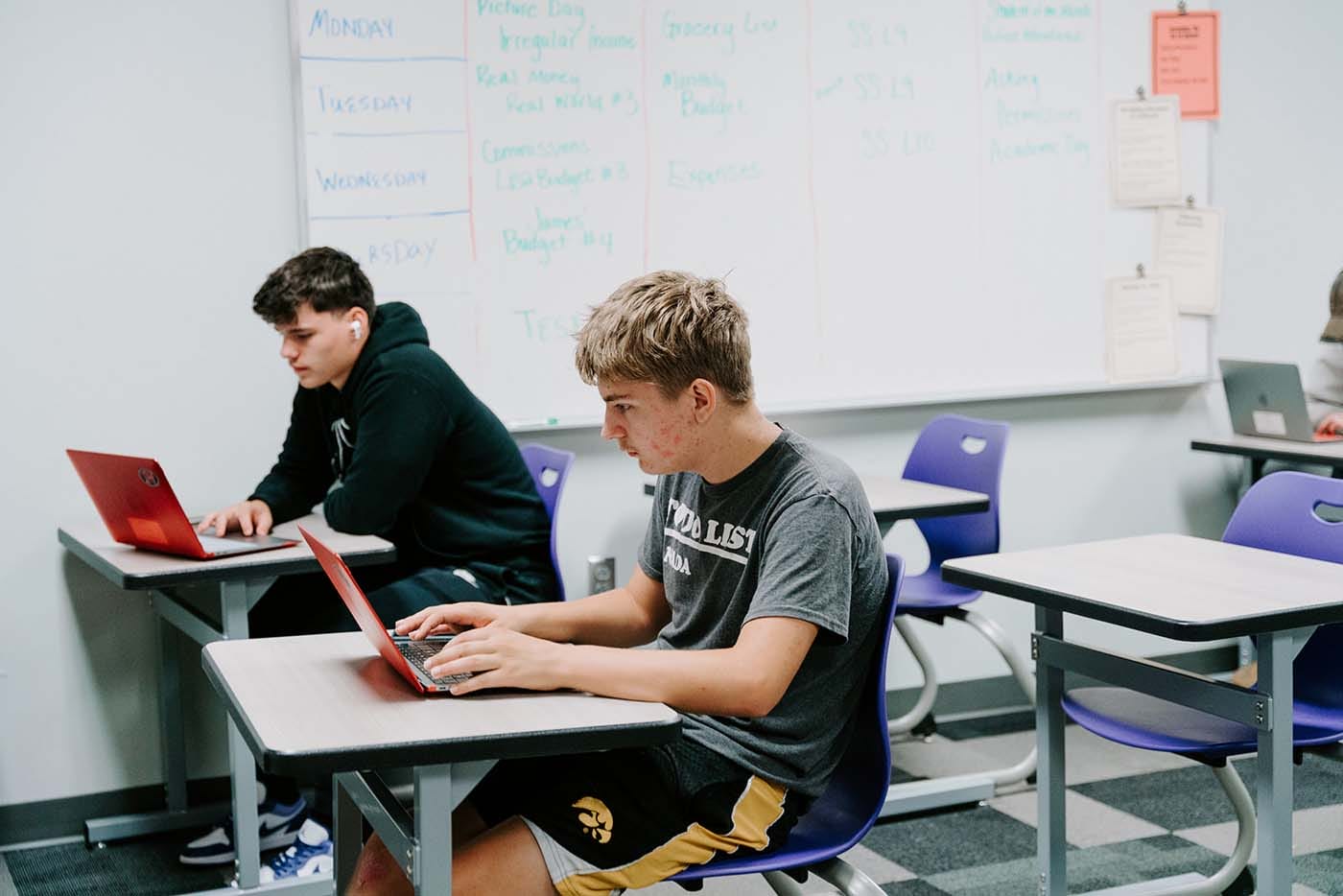 Students in their classroom, using a laptop to complete school assignments.