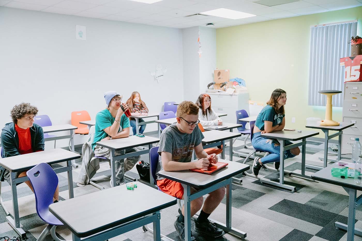 Students in their classroom, using a laptop to complete school assignments.
