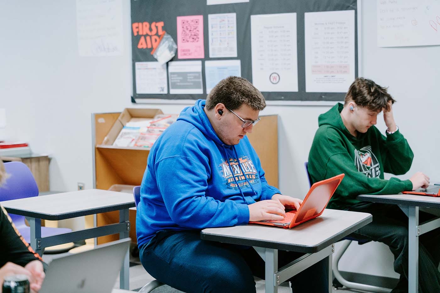 Students in their classroom, using a laptop to complete school assignments.