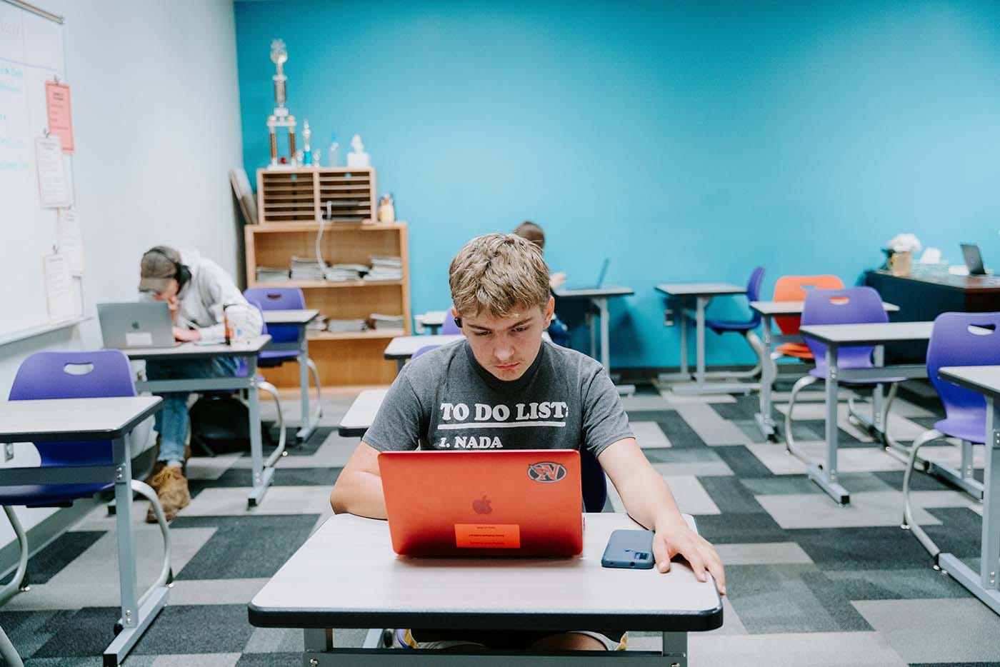Students in their classroom, using a laptop to complete school assignments.