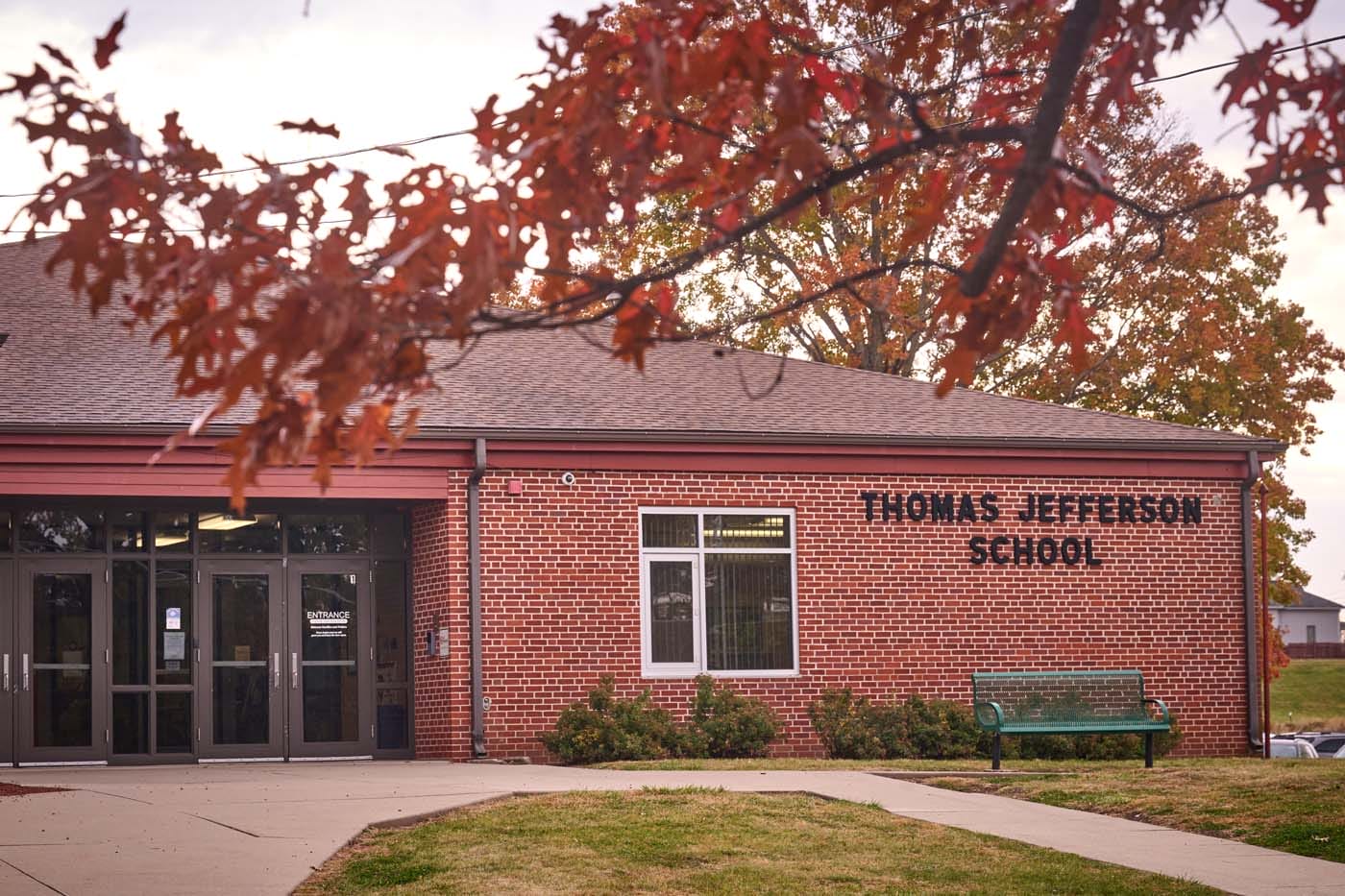 Exterior of a brick building, with a paved path leading to a door.