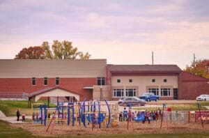 Exterior of a brick building, showing a playground in the foreground